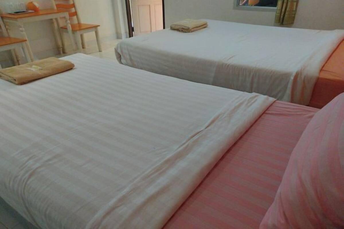 A hotel room with two beds, a desk, and a chair.