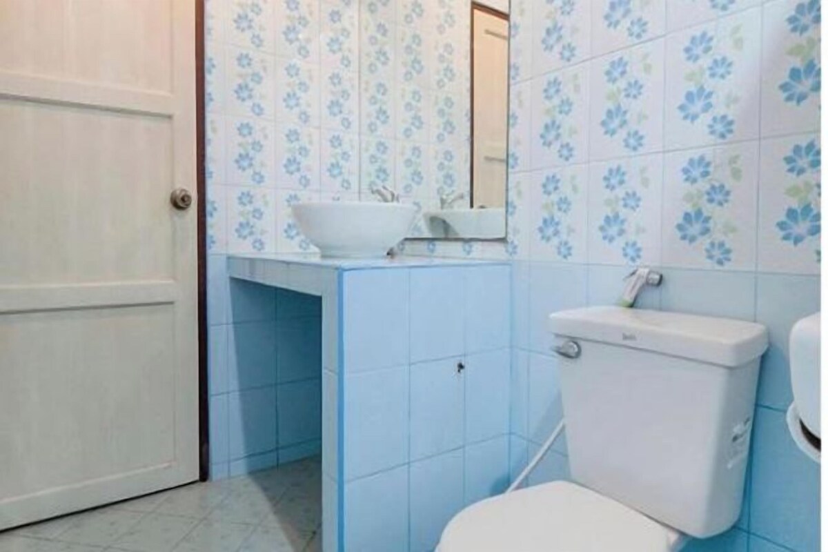 A bathroom with a white toilet, a white sink, and a mirror above it.