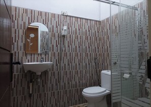 A bathroom with a modern design, featuring a toilet, sink, and shower.