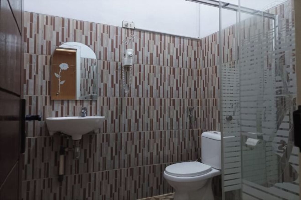 A bathroom with a modern design, featuring a toilet, sink, and shower.