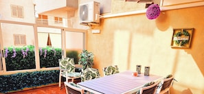 A patio with a table and chairs, air conditioning units, and a 'Welcome' sign.