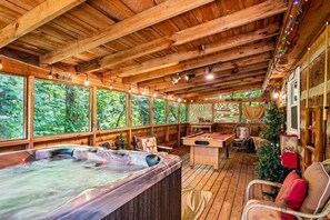 Een houten chalet met een jacuzzi, pooltafel en kerstboom.