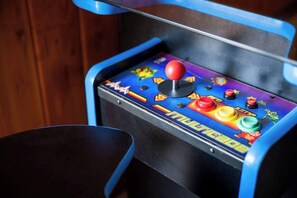 Une borne d’arcade ancienne, dotée d’un joystick et de boutons colorés.