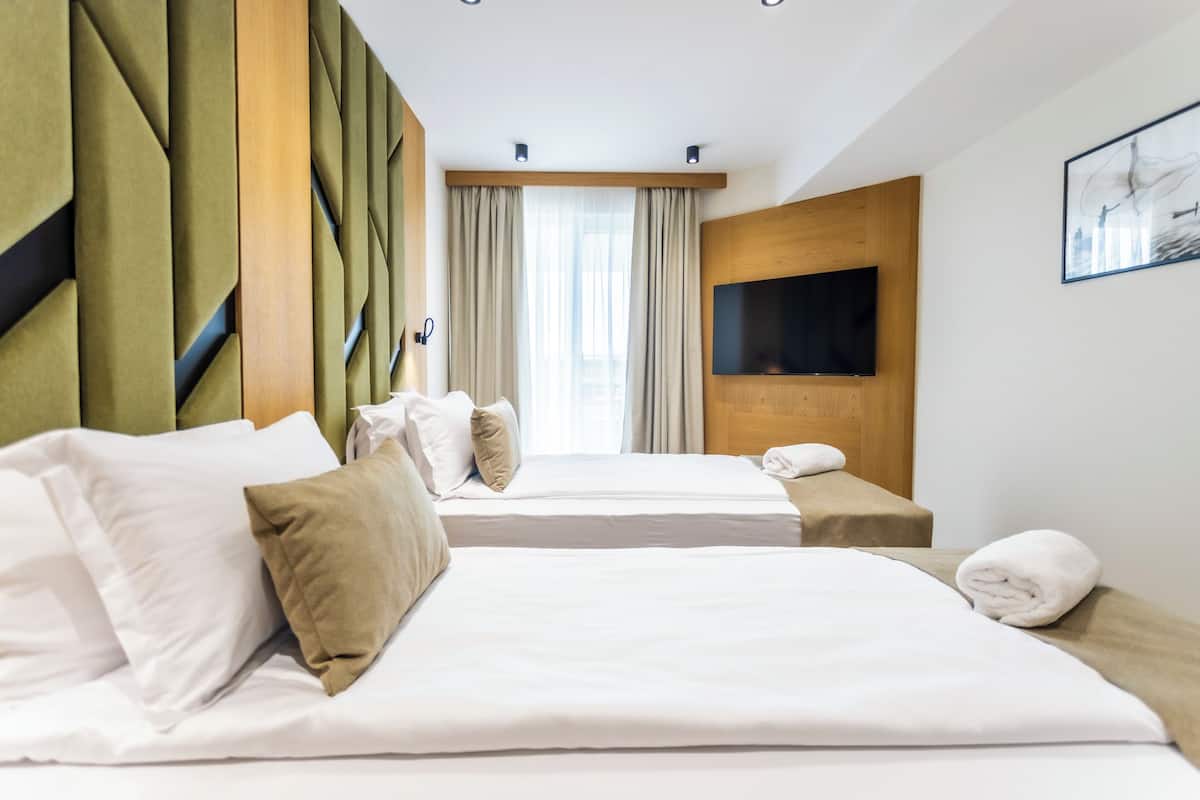 Deluxe Quadruple Room, Balcony, Beach View | In-room safe, laptop workspace, blackout curtains