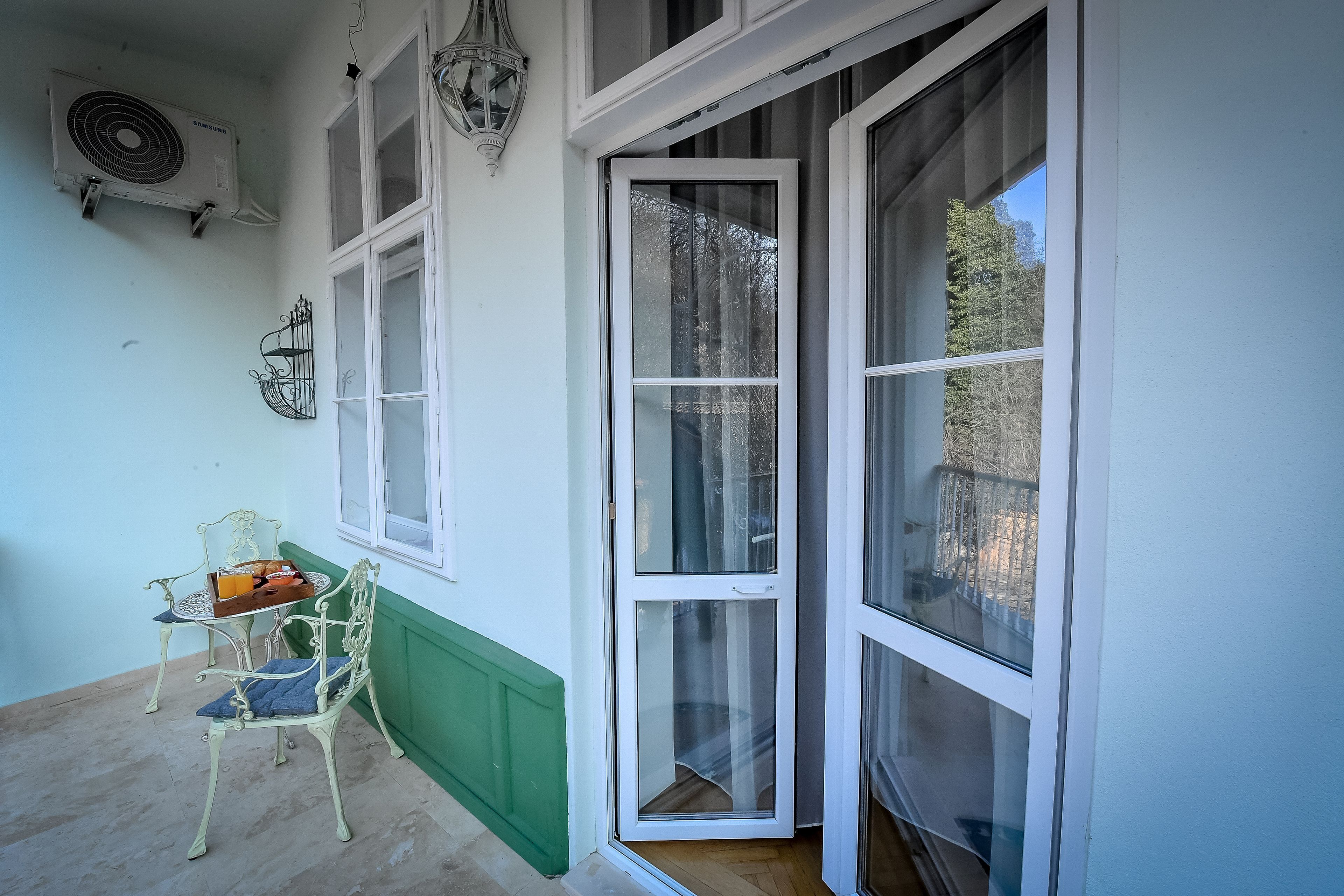 A room with a green wainscoting, a white-framed door, and a table with a basket.
