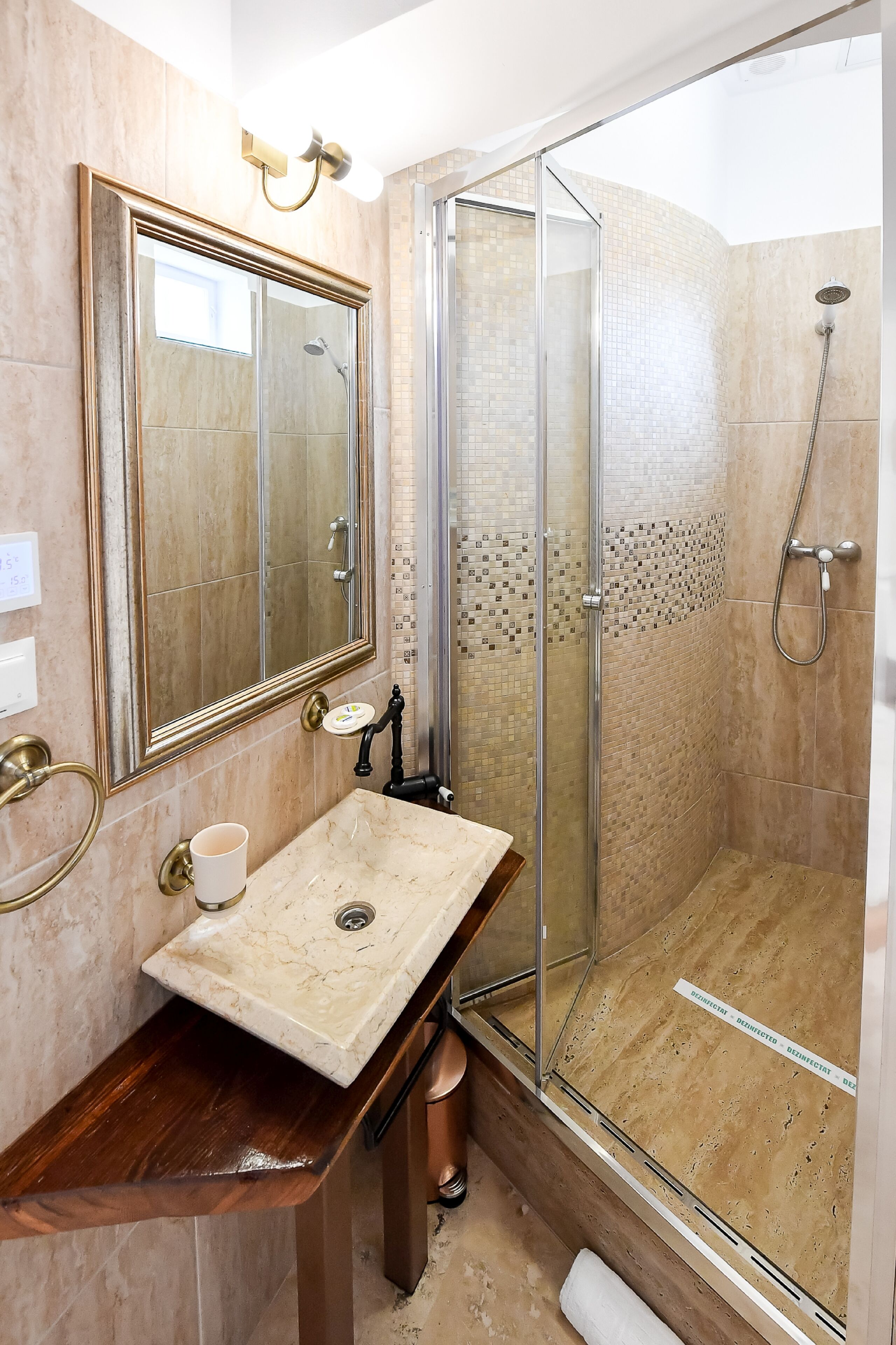 A bathroom with a marble sink, a large mirror, and a glass-enclosed shower.