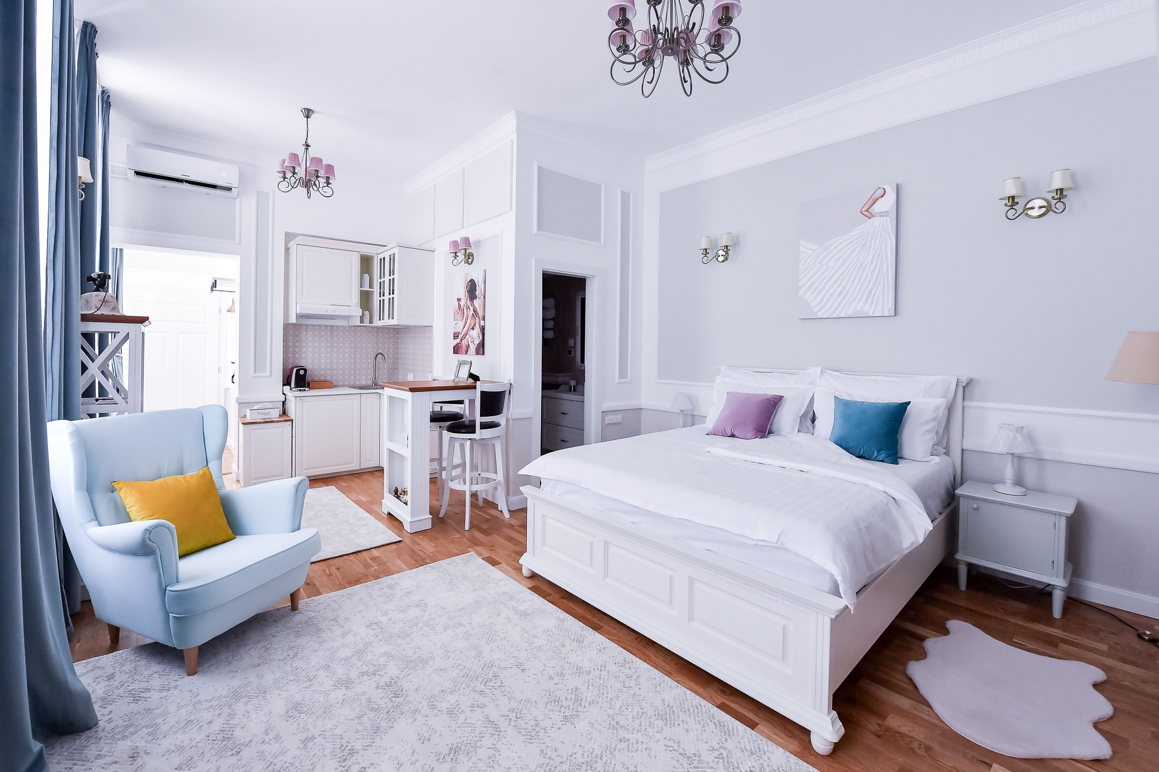 Un dormitorio con una cama grande, un escritorio y una silla. Hay un armario y un espejo en la habitación.