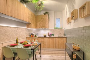 Eine moderne Küche mit Holzschränken, einem Esstisch für vier Personen und einem kleinen Fenster.