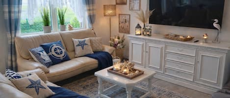 A living room with a sofa, a coffee table, a TV, and a cabinet.