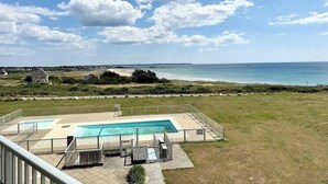 Zona de piscina con vista a la playa y al océano.