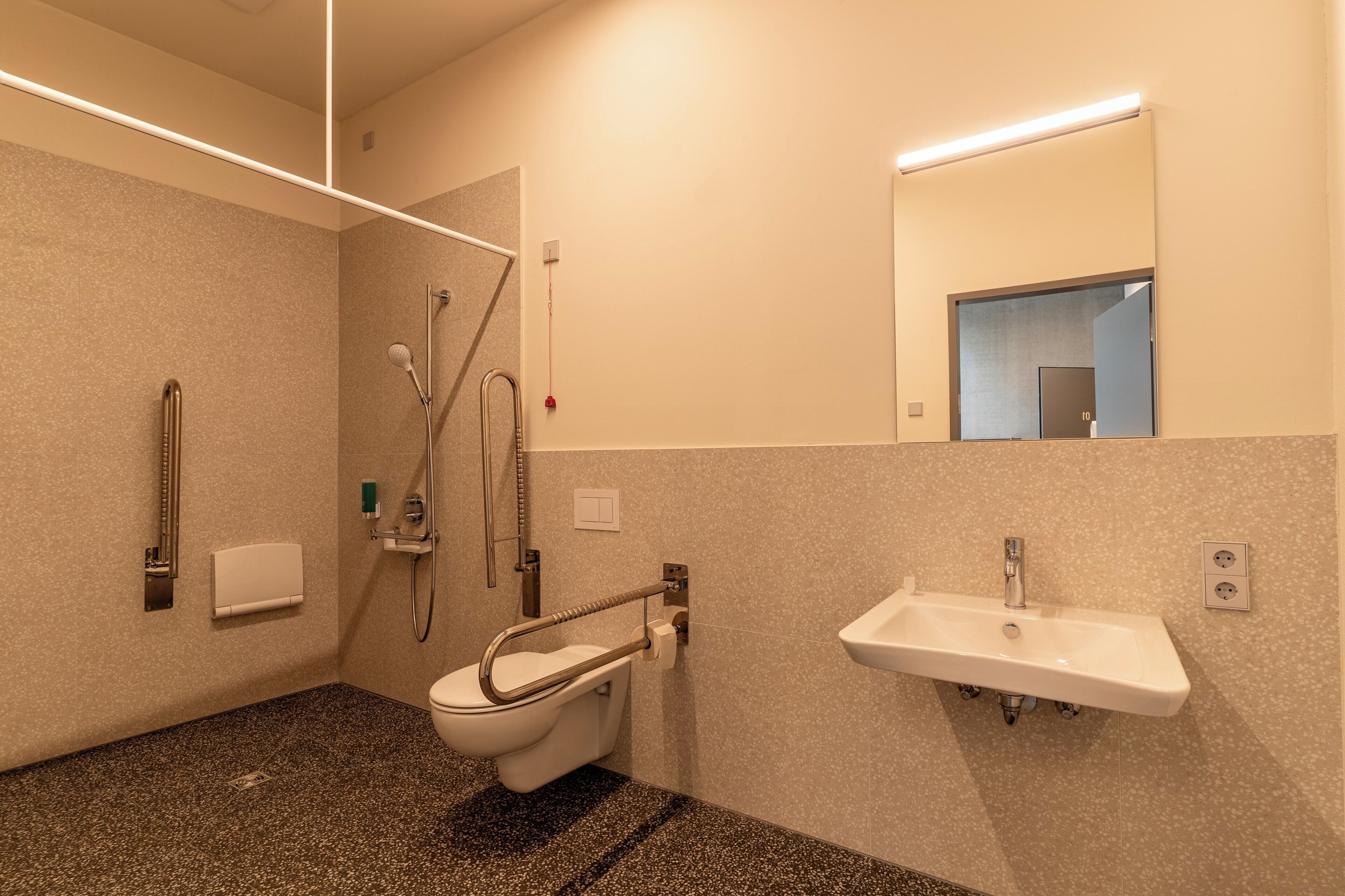 A modern bathroom with a toilet, shower, and sink.