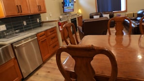 A modern kitchen with wooden cabinets, stainless steel appliances, and a dining area with a wooden table and chairs. - Fieldstone Manor Estate (Frankfort)