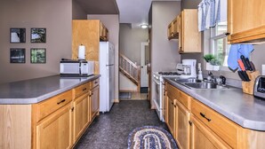 A modern kitchen with wooden cabinets, a stainless steel sink, and a microwave. - Estrold's Resort-Maple Cabin (St.Germain)
