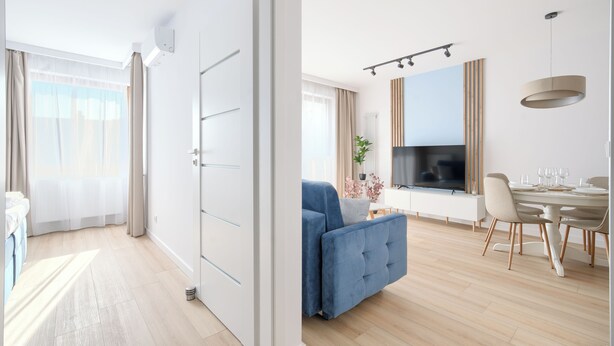 A modern living room with a blue sofa, dining table, and TV. - Apartamenty Sun & Snow Villa Verona (Mielno)