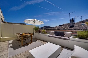 Enjoy dining al fresco on the rooftop terrace with a table, chairs, and comfortable seating area.