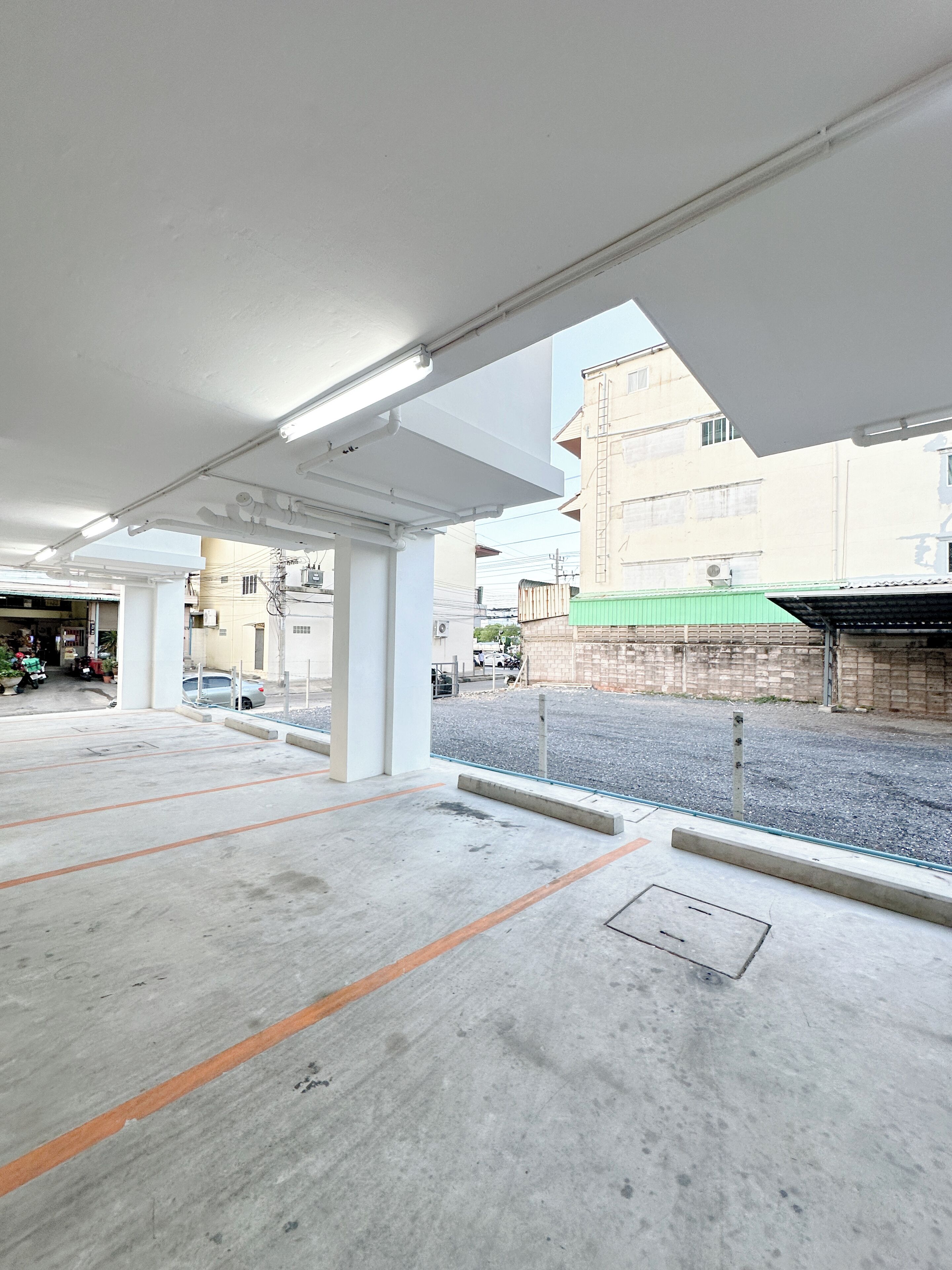Un garaje para estacionamiento con pisos de concreto y pilares blancos.