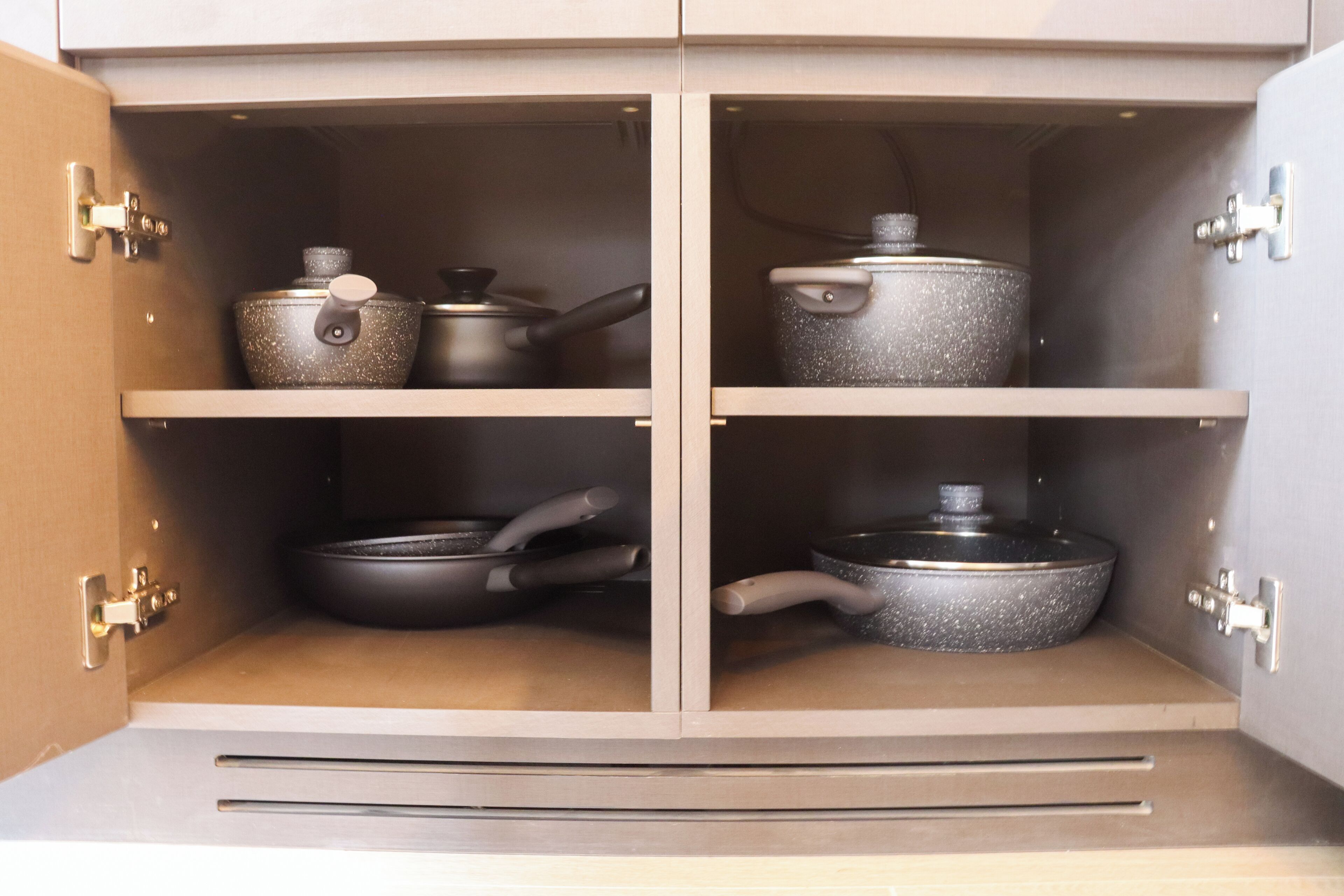 Un meuble de cuisine doté de quatre étagères, chacune contenant des ustensiles de cuisine.
