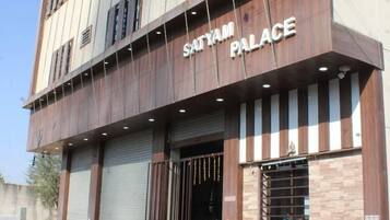 A building with the sign "SATYAM PALACE" indicating it is a hotel.