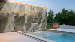 A pool with a marble wall and a waterfall feature. - Villa She Luxury by Villas Guide (Oprtalj)