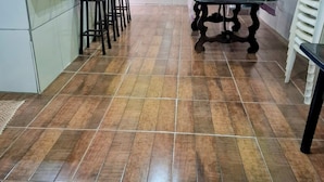 A kitchen with a tiled floor, a dining table with chairs, and a potted plant. - Chacara Rancho da Cris (Ibiuna)