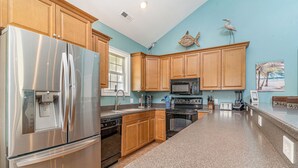 A kitchen with wooden cabinets, stainless steel appliances, and a granite countertop. - 242 Georges Bay Road (Whole) located in Bermuda Bay. (Murrells Inlet)