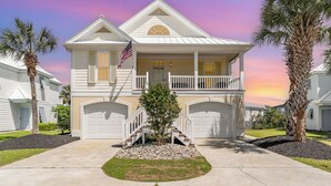 A two-story house with a front porch, a small tree, and a flag. - 242 Georges Bay Road (Whole) located in Bermuda Bay. (Murrells Inlet)