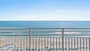 A balcony with a view of the beach, white railings, and several umbrellas. - ☀️Ocean Front Condo with Expansive Views-Daytona Ocean Walk Resort 1707☀️ (Daytona Beach)