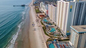 A coastal hotel with multiple swimming pools, a beach, and high-rise buildings. - ☀️Ocean Front Condo with Expansive Views-Daytona Ocean Walk Resort 1707☀️ (Daytona Beach)