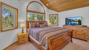 A bedroom with a wooden bed, a nightstand, a dresser, and a television. - Pet Friendly, AC, Hot tub, Ping pong, guest fav (Sunriver)