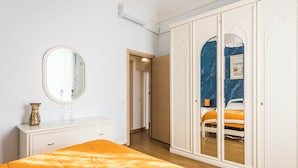 Ein Schlafzimmer mit Bett, Schminktisch, Spiegel und Kleiderschrank.