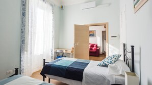 Ein Schlafzimmer mit zwei Betten, einem Schreibtisch und einem Stuhl.