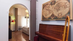 A room with a wooden bench, a globe map on the wall, and a wooden easel. - Spacious 2 Bd Pireas Apt w Cozy Balcony (Piraeus)