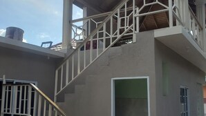A two-story building with a staircase leading to an upper balcony.