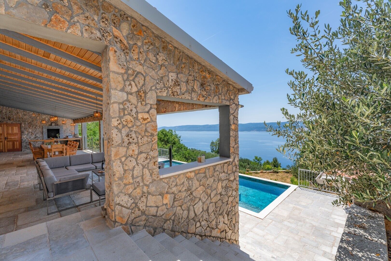Ein Steinhaus mit Pool und Meerblick.