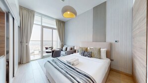 Una habitación de hotel moderna con una cama grande, un escritorio y vistas a la ciudad.
