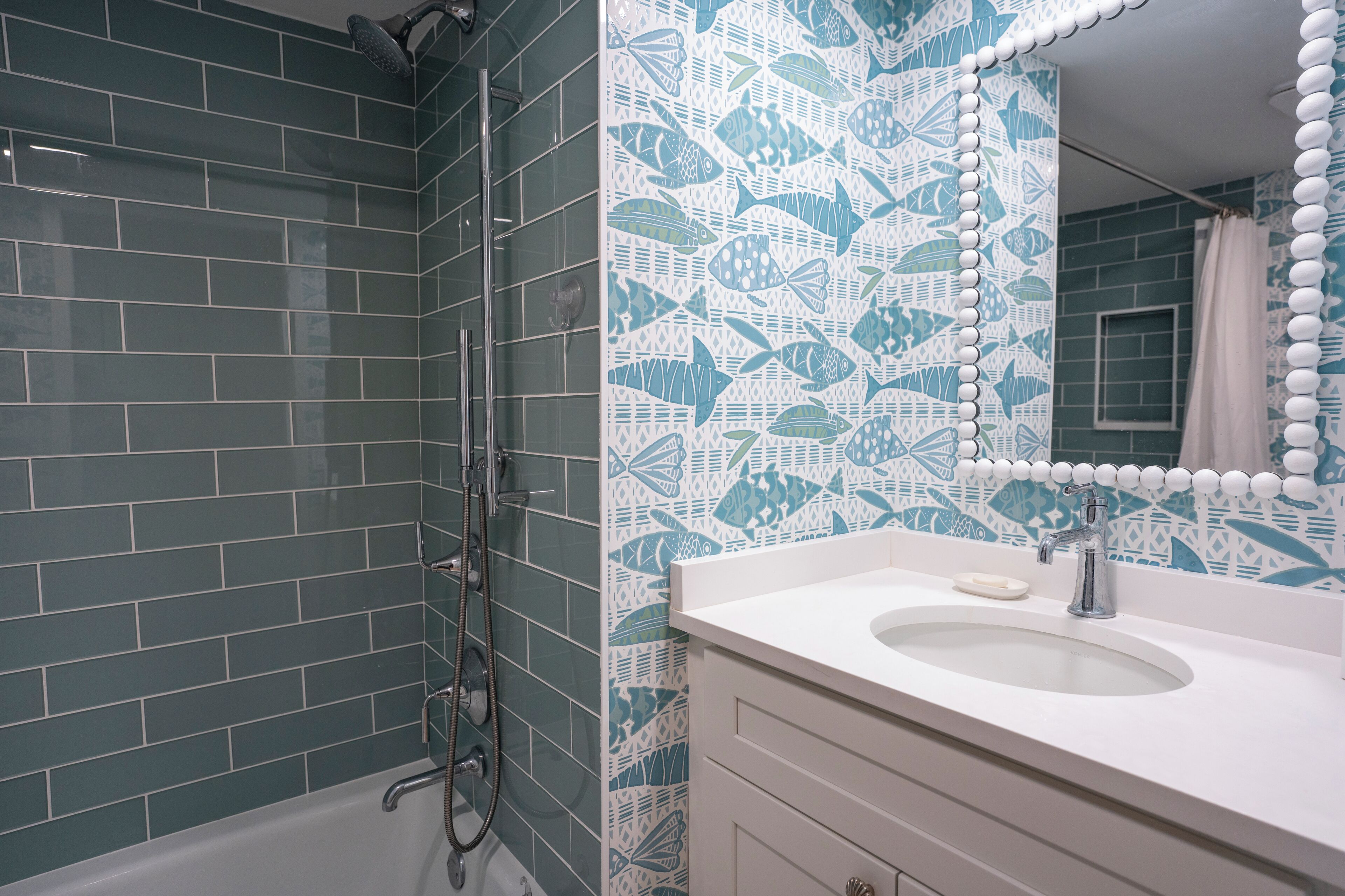 A bathroom with a shower, a sink, and a mirror.