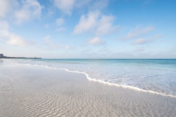 A beach with a clear sky and gentle waves.