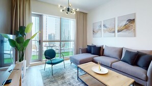 A modern living room with a sectional sofa, a dining table, and a large window offering a city view.