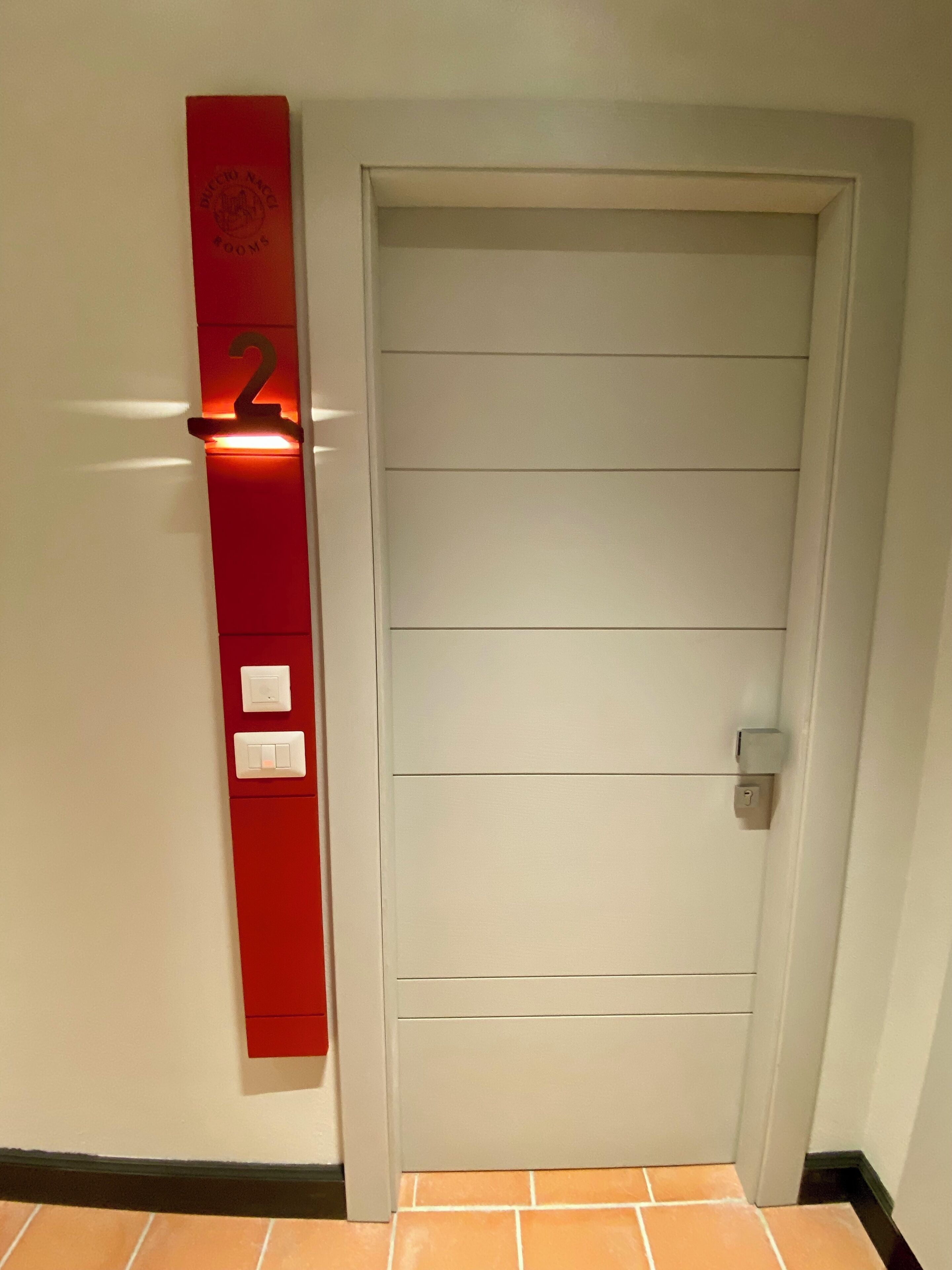 A door with a red mailbox and a number '2' sign.