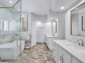 Une salle de bain moderne avec une douche en verre, un sol carrelé en marbre et un grand miroir.
