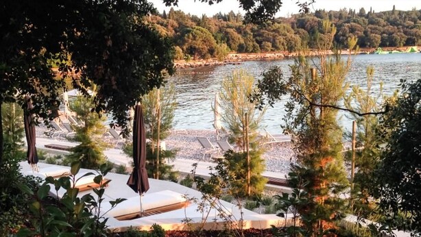 Un complexe hôtelier au bord du lac, doté de chaises longues et offrant une vue sur le lac.