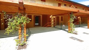 A two-story building with a wooden balcony and a covered outdoor area. - Seaside Apartment in Santa Cruz Tenerife (Lignano Sabbiadoro)