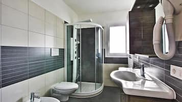 Ein modernes Badezimmer mit einer Duschkabine, einem Waschbecken und einer Toilette.