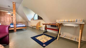 Une pièce avec un plafond en pente, un lit, un bureau, une chaise et une petite table.