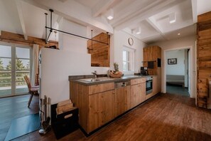 Una cocina moderna con armarios de madera, una isla central y un ventanal amplio.