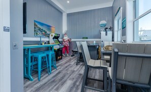 A modern interior with a blue and grey color scheme, featuring a bar area with stools, a counter, and a person in a Santa hat.