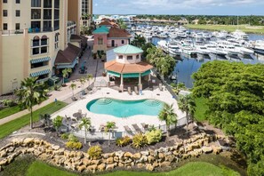 A marina with boats, a swimming pool, and a building with a green roof.