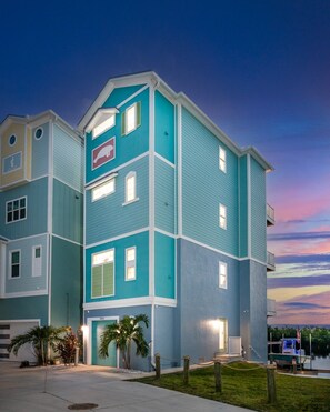 A multi-story residential building with a flat roof and a prominent sign on the front. - Manatee Suite 2 / Funky Fish House at Cape Harbour (Cape Coral)
