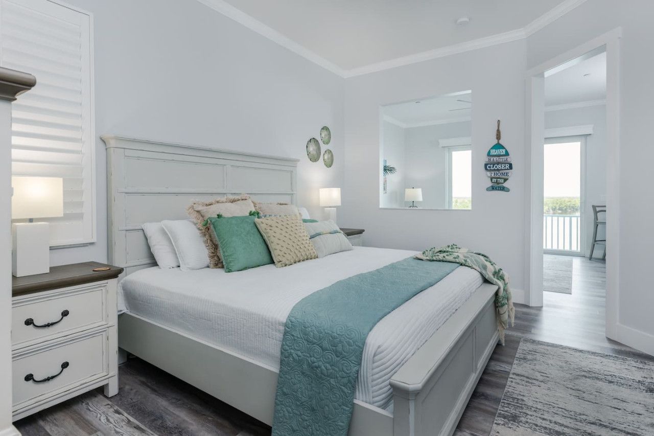 A bedroom with a bed, bedside tables, a dresser, and a mirror.