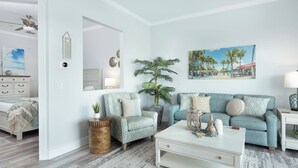 Un salón moderno con un sofá azul claro, una mesa de centro blanca y una planta grande.
